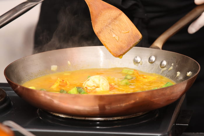 銅フライパンで煮込み料理を作るイメージ