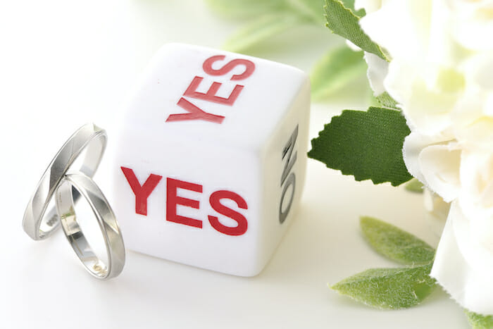 婚活アプリ・サイトの質問を示す婚約指輪とyes/noが書かれたサイコロ