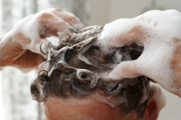 頭皮をマッサージするように優しく洗っている男性